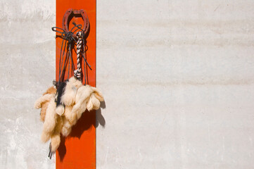 Houseshoe and woolen tails as a talisman for a good luck on the white wall with red line background