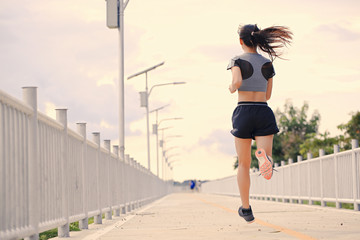 A good-looking woman is jogging in the evening.