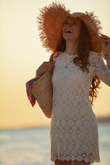 smiling woman on beach at sunset having fun time