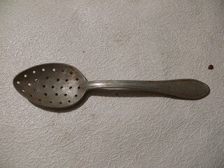 aluminum spoon in holes on a white background.