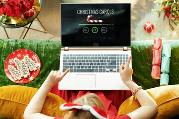 modern little princess listening Christmas songs on laptop