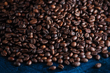 roasted aromatic coffee beans closeup sprinkled on a table