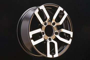 aluminum die cast alloy wheel for powerful SUV close up on black background. polished surface