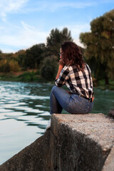 girl alone sits near the river