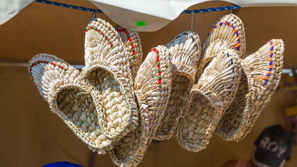 Russian folk art. Wicker bast shoes on sale exhibition.