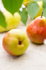 Fresh pears with leaves in a on wooden background.