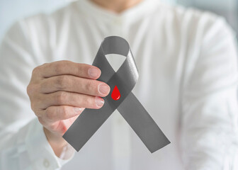 World diabetes day, Diabetes Awareness ribbon with red blood drop on grey bow color in person's...