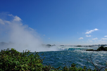 Magnificent Niagara Falls as seen near the main waterfall ledge showing the large rampant of mist produced.