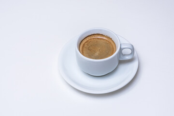 Mesa blanca con taza de café en lado derecho