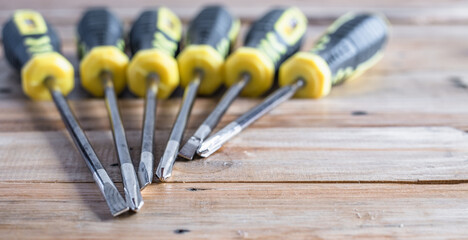 Set of screw driver both minus and plus head in yellow and black handle on wooden top table background