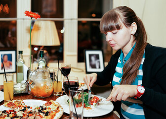 Portrait of young girl eating food in restaurant