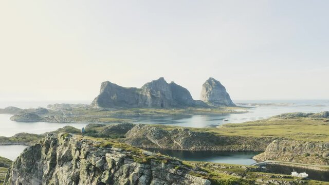 Man hiking alone on mountain ridge travel adventure active lifestyle vacations with backpack outdoor in Norway Helgeland islands landscape