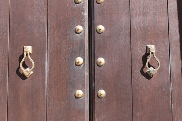 Wooden old door with door handles in Granada, Andalusia, Spain.