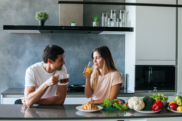 Photo of young couple starting the day together with coffee in the kitchen