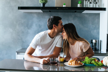 Photo of young couple starting the day together with coffee in the kitchen