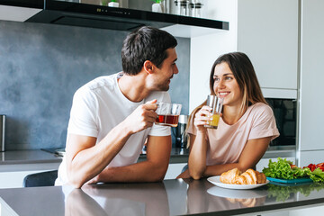 Photo of young couple starting the day together with coffee in the kitchen