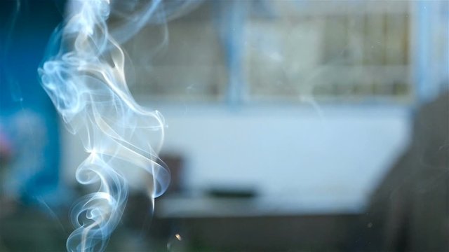 Beautiful gray smoke on a blue background. Close-up. Slow motion