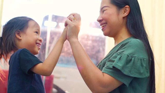 Happy loving family. Mother and her daughter child girl playing high five and hugging