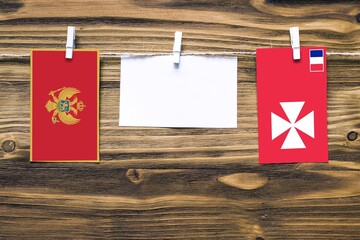 Hanging flags of Montenegro and Wallis And Futuna attached to rope with clothes pins with copy...