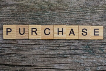 Fototapeta premium purchase word made from brown wooden letters on gray table