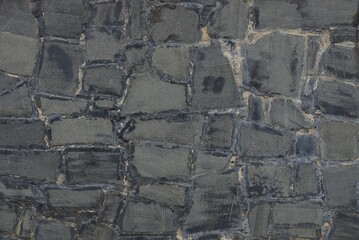 gray stone background of cobblestones and plaster in the wall