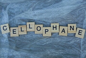 wooden word lies on a piece of gray crumpled cellophane