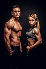 Sporty young couple posing on black background