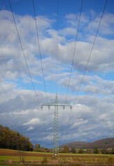 Strommasten hintereinander mit bewölktem Himmel