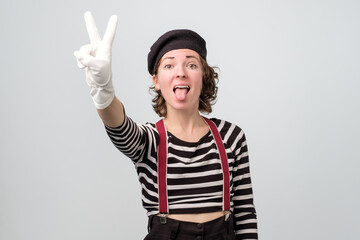 Caucasian mime woman showing victory gesture at isolated background. Studio shot