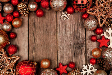 Red and gold Christmas ornament frame. Top view on a rustic wood background.