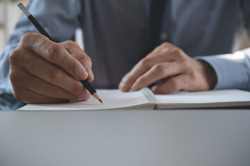 Businessman writing on notebook