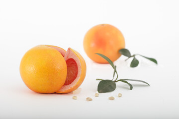Fresh grapefruits with leaves isolated on white background.Two ripe, juicy grapefruits, one cut.