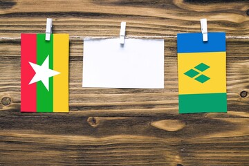 Hanging flags of Myanmar and Saint Vincent And The Grenadines attached to rope with clothes pins...