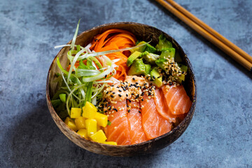 Hawaiian poke bowl with raw salmon, pickled carrots, mango and avocado