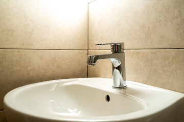 chrome faucet with ceramic washbasin in the bathroom
