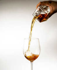 wine is poured into a glass on a light background