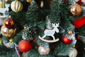 Christmas spruce toy moose with the inscription Merry Christmas on a fir tree with lights