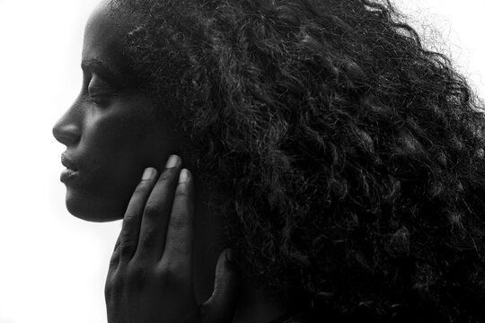 Close up portrait of an attractive dark skinned woman with long hair and strong features, black and white