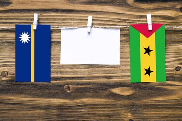 Hanging flags of Nauru and Sao Tome And Principe attached to rope with clothes pins with copy space...