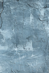 The texture of gypsum or alibaster cracked plaster on the wall is a thick layer. Gradient blue...