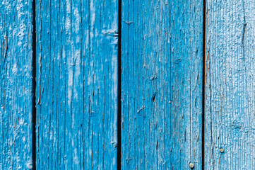 Old and peeling paint Over time, the blue paint peeled off from the old boards and the wood texture cracked. Vintage Abstract Grunge Background