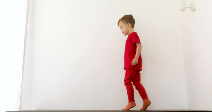 Smiling boy walking on tiptoes white background at home