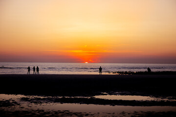 Fototapeta na wymiar Groupes de gens regardent le coucher du soleil