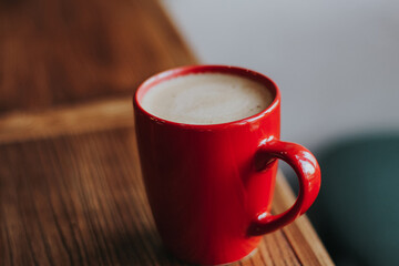 red cup with mokachino coffee in a cafe on a dark background