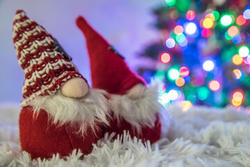 Christmas gnome decorations on fluffy background and colorful christmas tree blurry lights and...