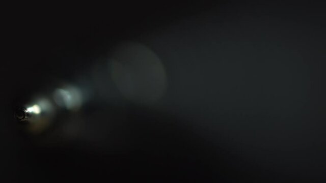 Ball point pen extreme close up macro light passes through frame to reveal it in great detail isolated in dimly lit area