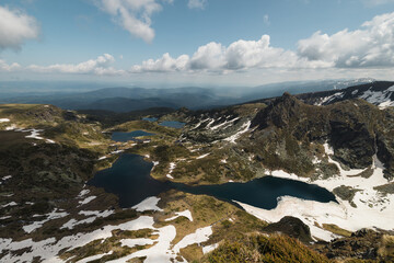 Panorama view of The Seven Rila Lakes as seen from Mount Ezere covered with snow during early summer day at Rila Mountain (near Sofia, Bulgaria, Europe)