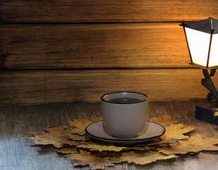 cup of fragrant tea on a wooden table against a background of autumn leaves, a great reason to warm...