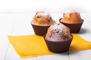 Three Handmade muffins on a wooden table