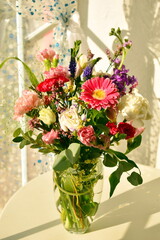 Bouquet of flowers in a vase on the table. Beautiful blooming bouquet of flowers on the window.